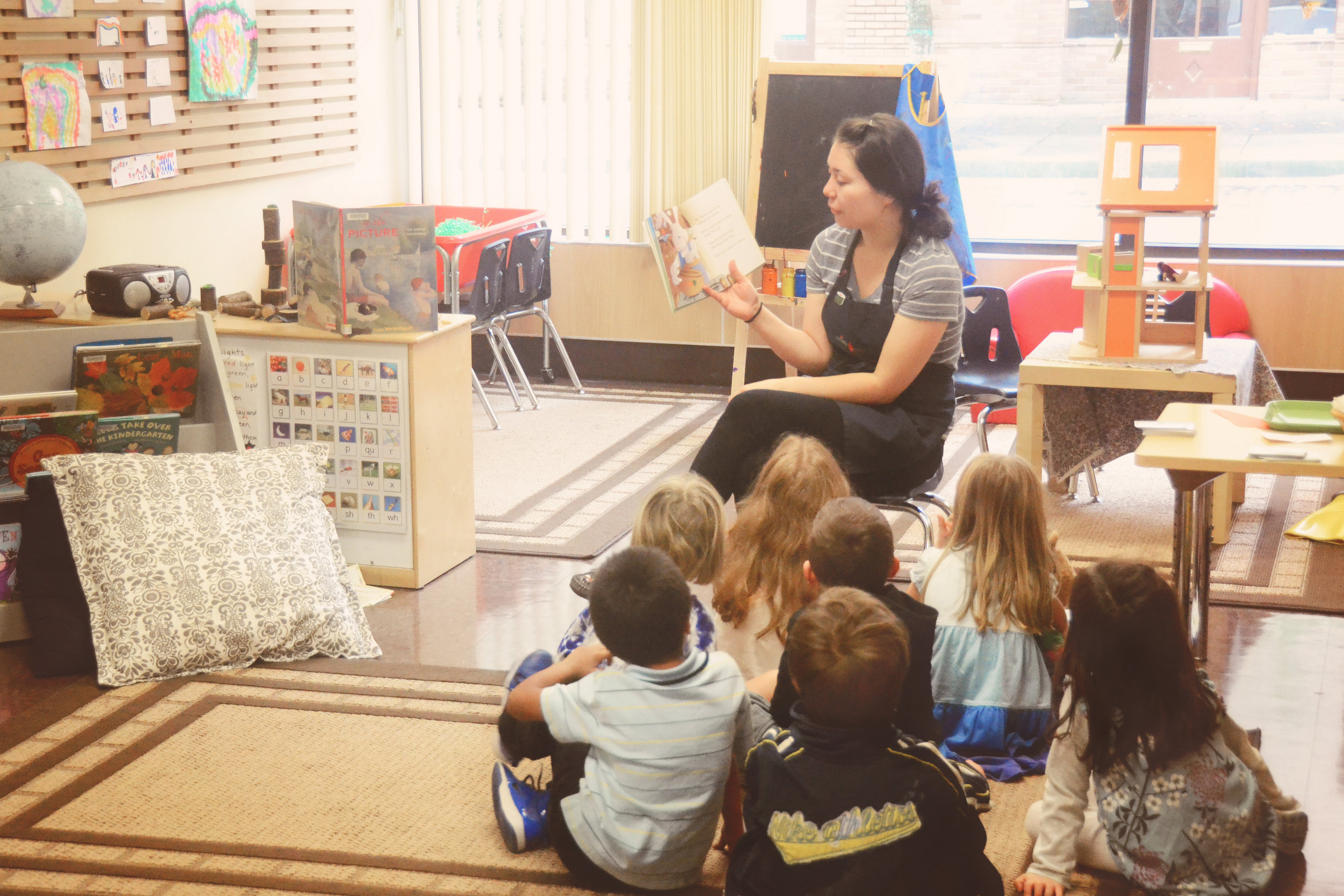 Montessori teacher overseeing children as they independently explore Montessori math materials.