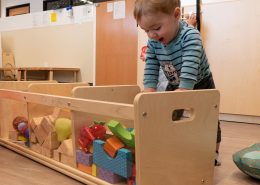 Child using Montessori sandpaper letters to practice early literacy and phonetic sounds.